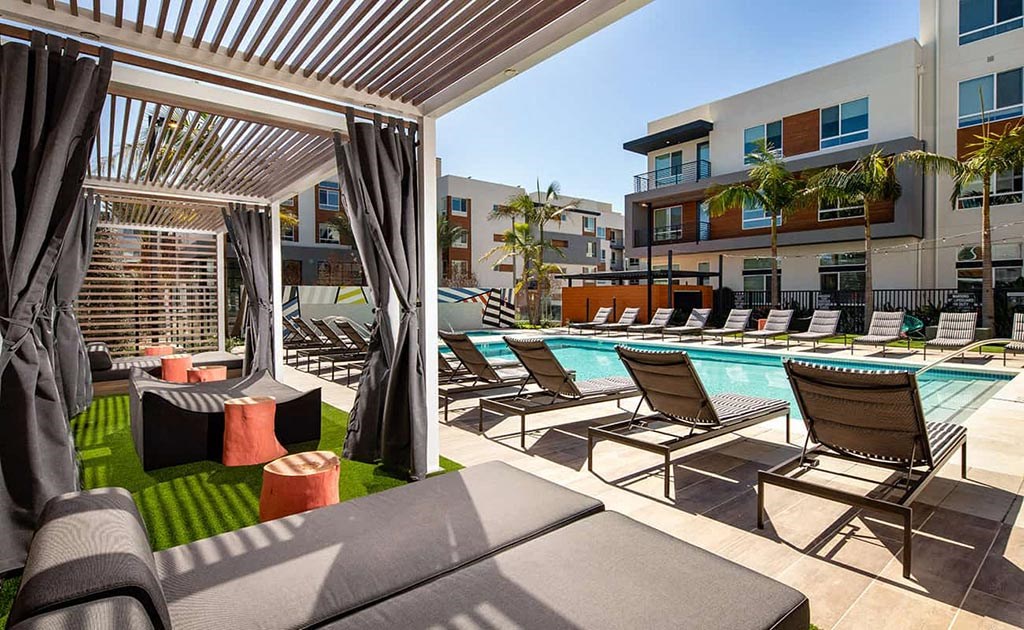 a pool area with lounge chairs and a poolside