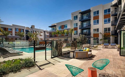 an apartment complex with a swimming pool and a patio with furniture