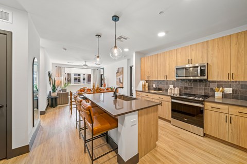 A kitchen with wooden cabinets and a white island.