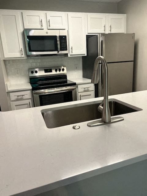 a kitchen with a sink a stove and a microwave