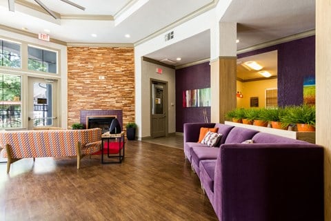 a living room with purple furniture and a fireplace