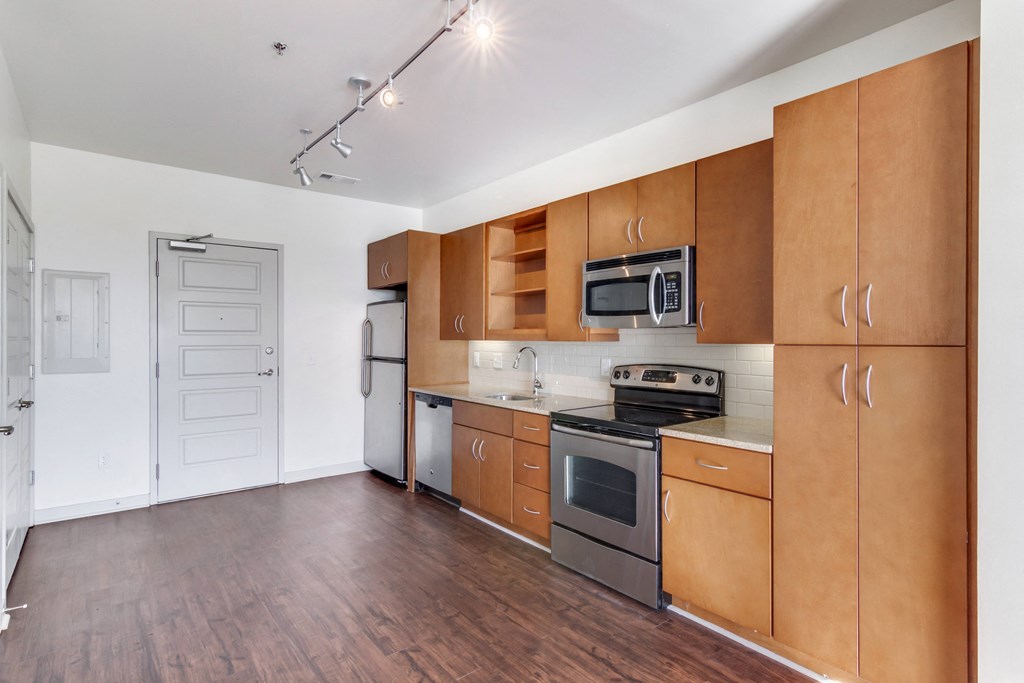Pet Friendly Apartments in Nashville, TN - 12 South Apartments - Kitchen area with cabinet space, stainless steel appliances, open concept wood-style flooring.