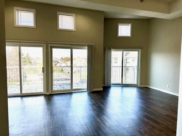 an empty living room with a wood floor and sliding glass doors