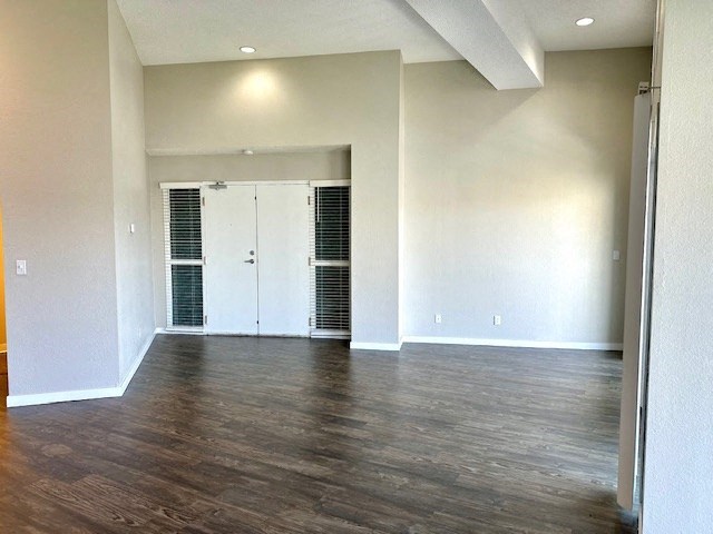 an empty living room with white walls and wood floors