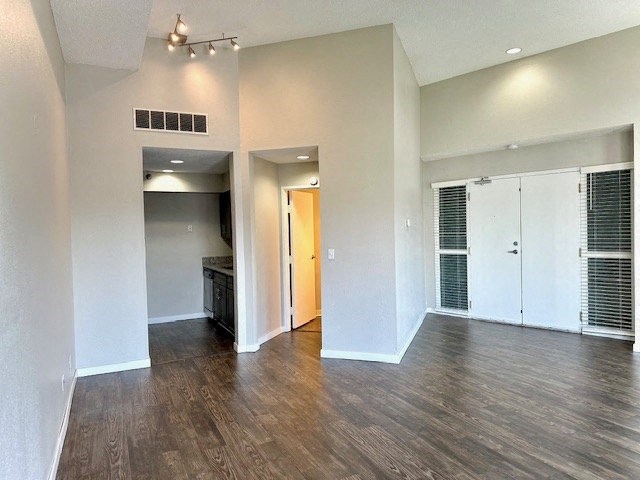 an empty living room with white walls and wood floors
