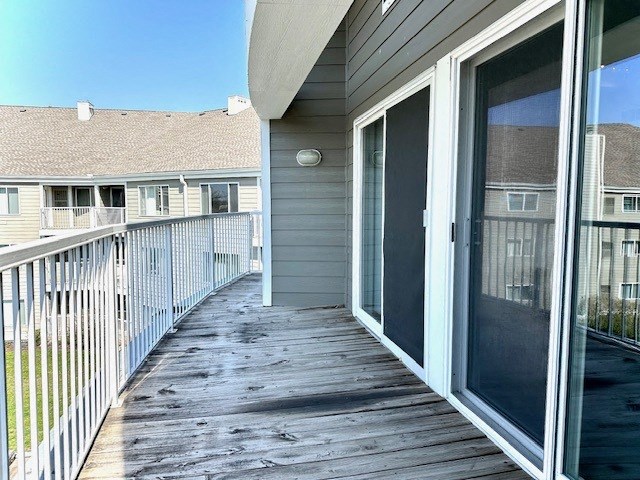 a porch with a glass door and a house in the background