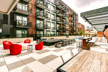 an outdoor patio with tables and chairs at a building with a pool
