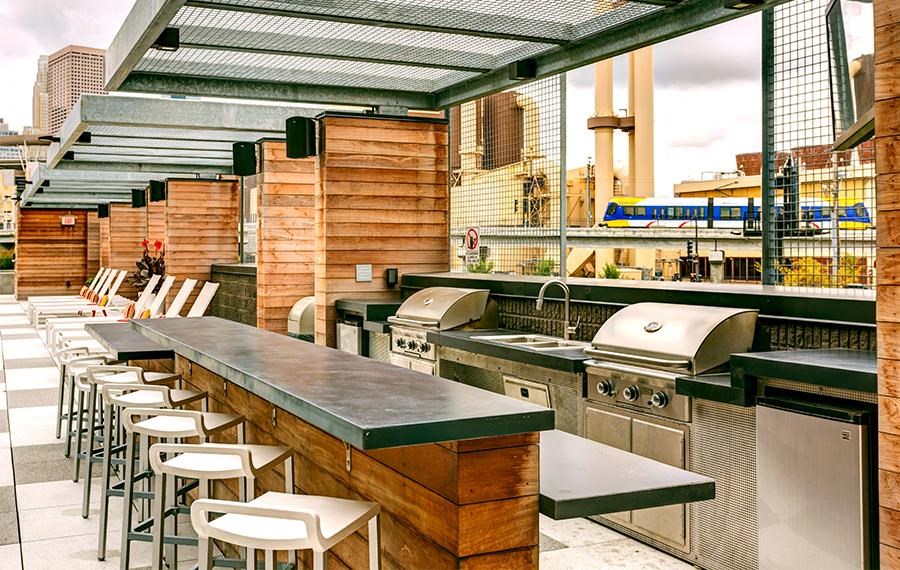a bar with a row of bar stools and stainless steel appliances