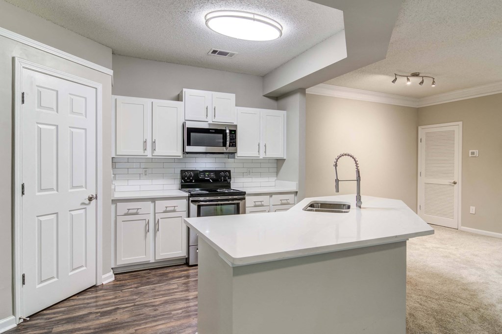 Woodstock, GA Apartments – Lea Woodstock – Luxury kitchen with quartz counter tops, white cabinets, stainless-steel appliances and hardwood floors