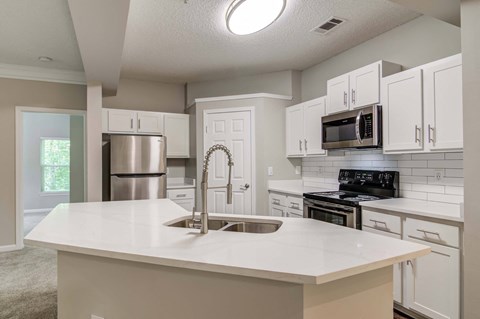 an open kitchen with white counter tops and a sink