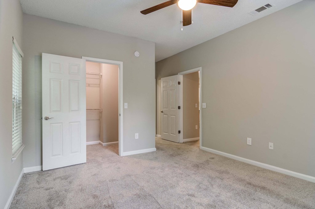 Apartments In Woodstock for Rent – Lea Woodstock – bedroom with plush carpeting, ceiling fan and a view of the closet