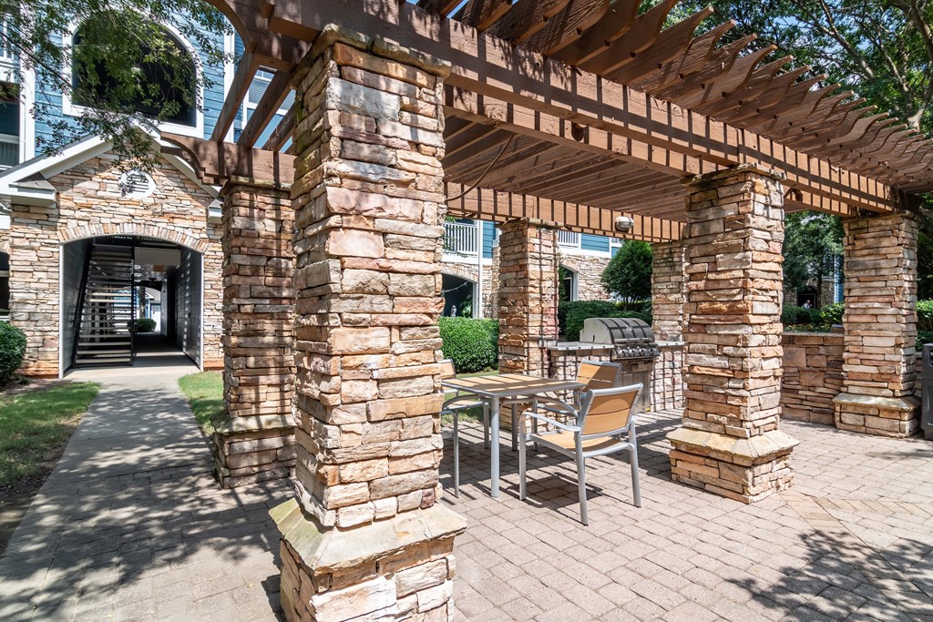 Apartments In Woodstock for Rent – Lea Woodstock – BBQ Grill area under a pergola with picnic tables and chairs