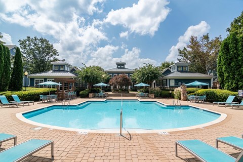 Apartments in Woodstock, GA - Lea Woodstock - Swimming Pool With Turquoise Lounge Chairs, Umbrella Seating, Landscaped Courtyard, And Clubhouse.