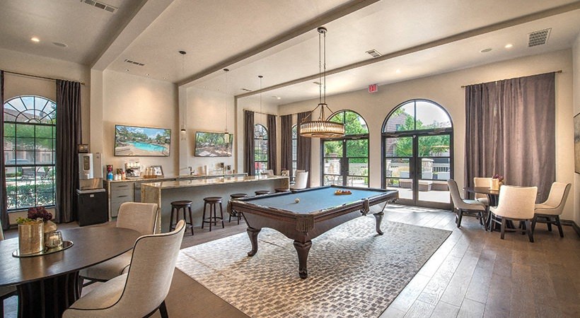 a game room with a pool table and a bar