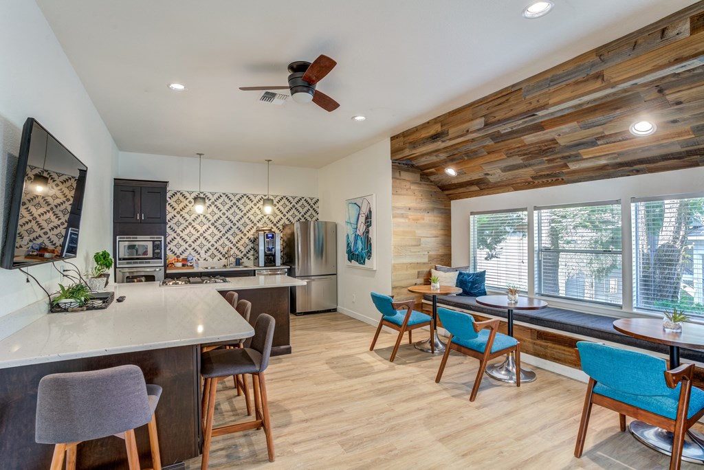 a kitchen and living room with a large window and a ceiling fan