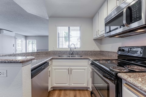a kitchen with granite counter tops and white cabinets