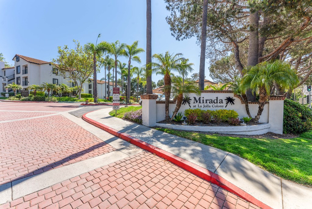 the entrance to mira la quinta apartments with palm trees