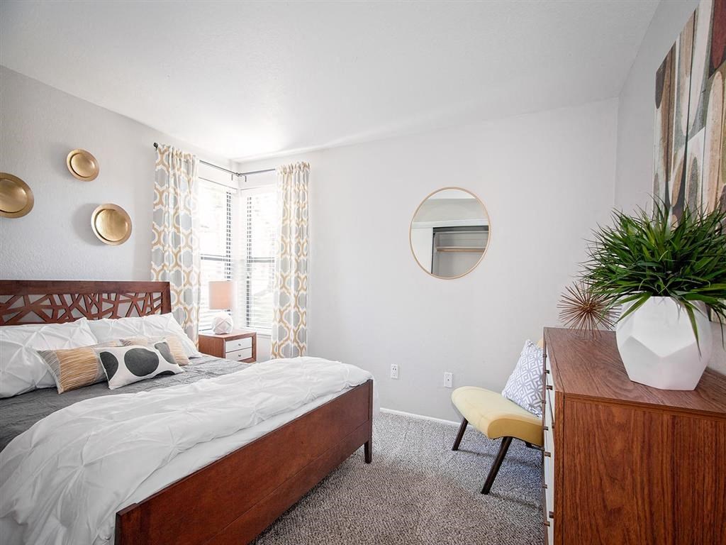 a bedroom with a bed and a dresser and a window