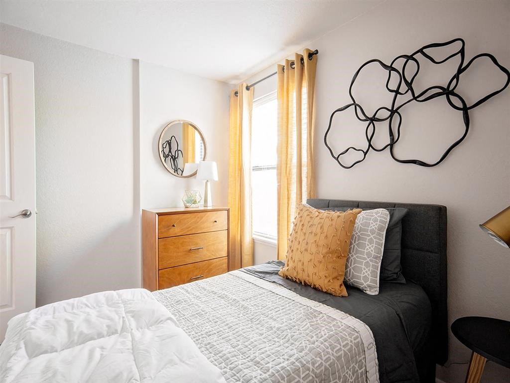 a bedroom with a bed and a mirror on the wall