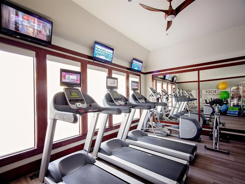 a gym with treadmills and televisions