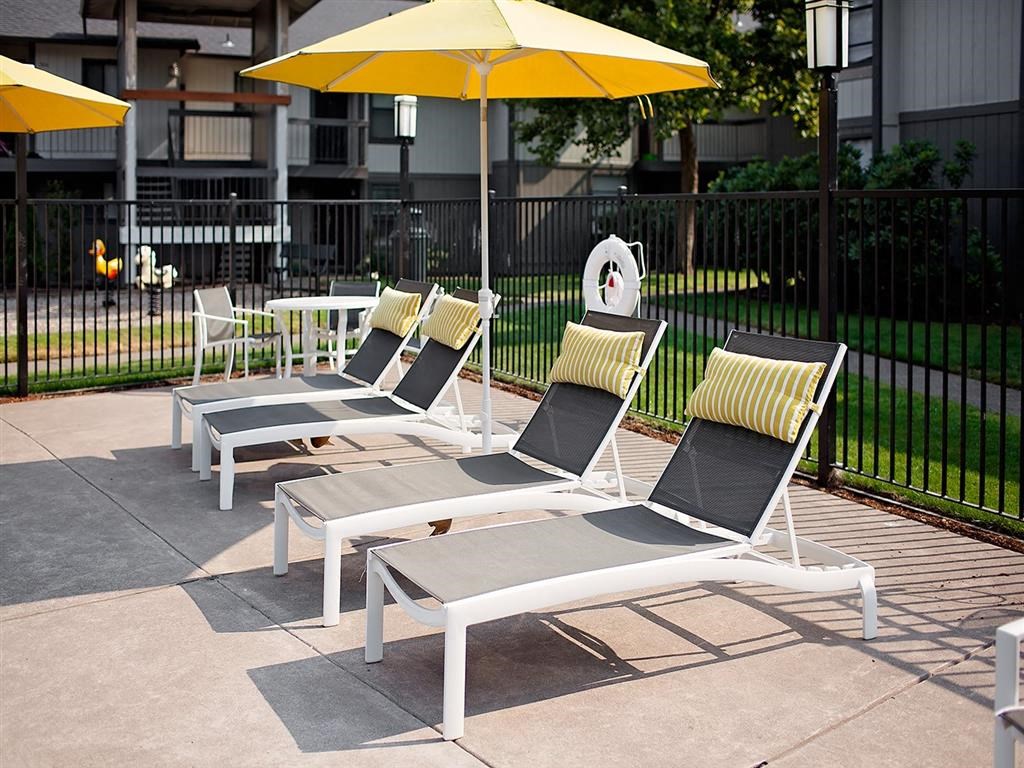 a group of lounge chairs with yellow umbrellas