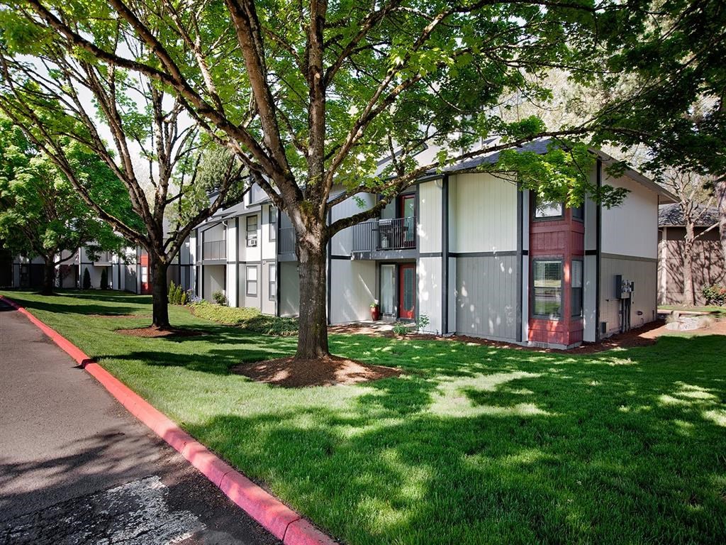a building with a red curb and trees in front of it