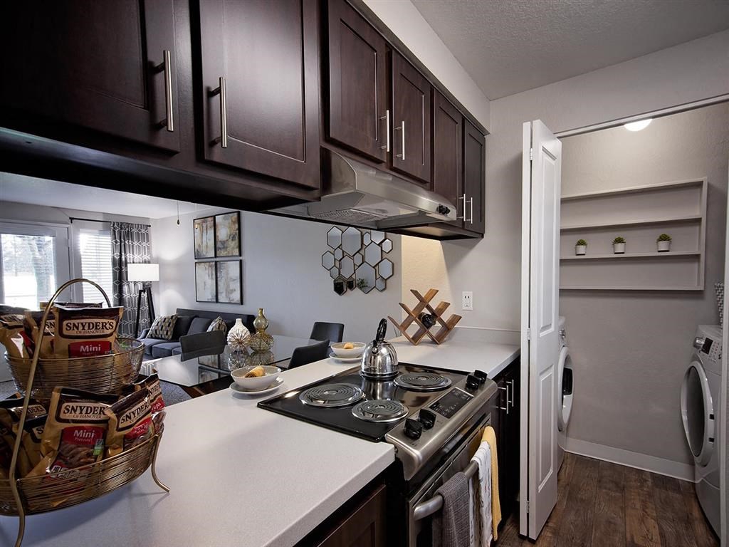 a kitchen and living room with a stove and a refrigerator