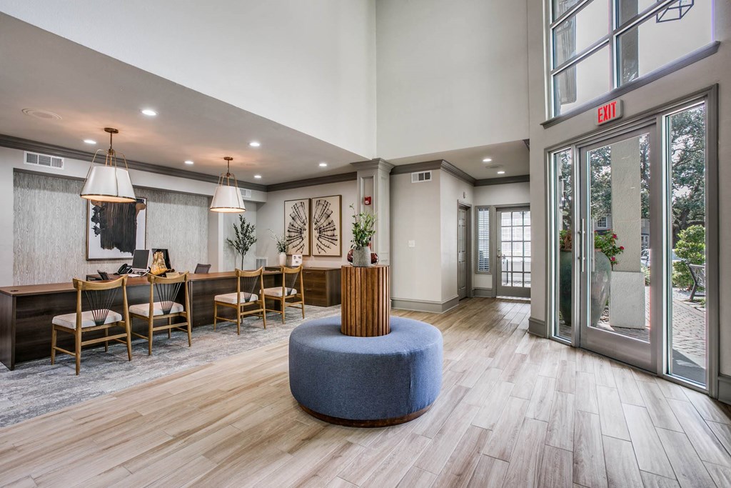 a lobby with a table and chairs and glass doors