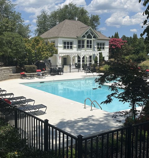 a swimming pool with a house in the background