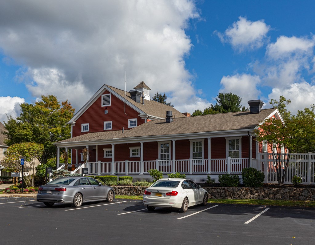 Orchards Apartments Marlborough ma apartment loft style apartments photo of clubhouse exterior with red siding and white rails next to parking lot
