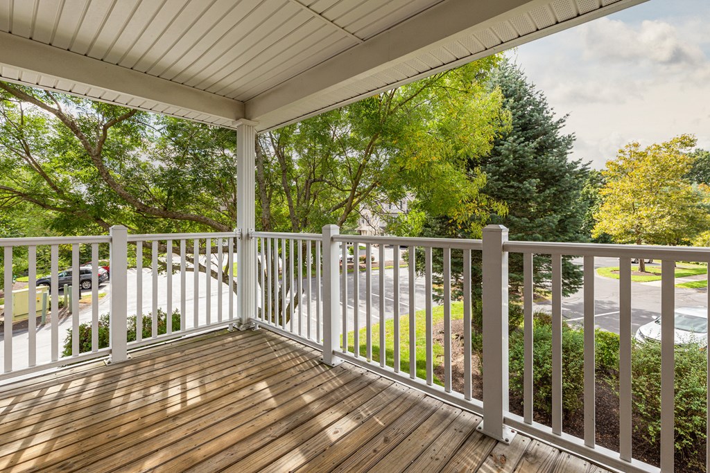 Orchards Apartments Marlborough ma apartment loft style apartments photo of large private outdoor balcony with wood floor and white railings overlooking green trees and landscape