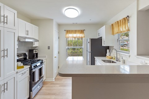a kitchen with white cabinets and stainless steel appliances and a counter top