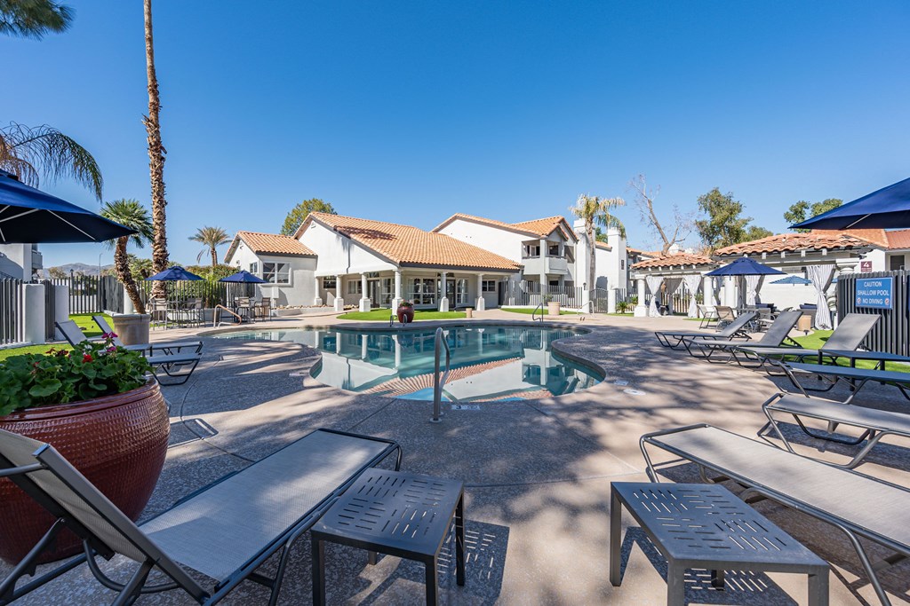 a pool with tables and chairs around it at the resort