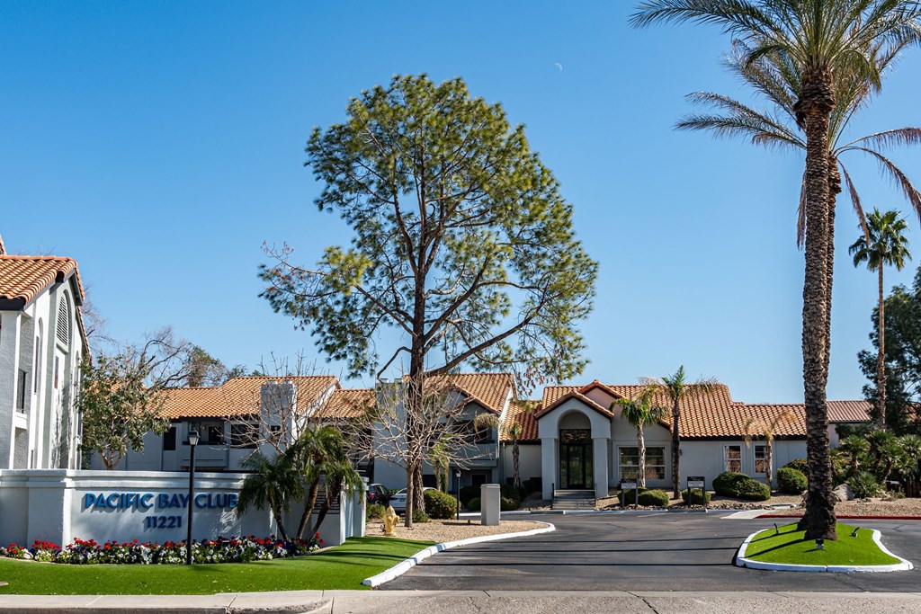 a building with palm trees and a street in front of it