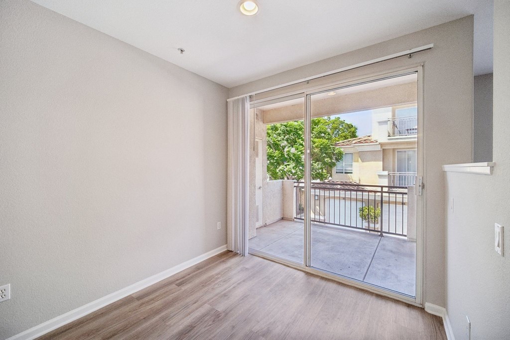One Bedroom Modern Apartments in Camarillo, CA - Allure - Living Area with Wood-Style Floors and Sliding Glass Door to Private Outdoor Balcony.