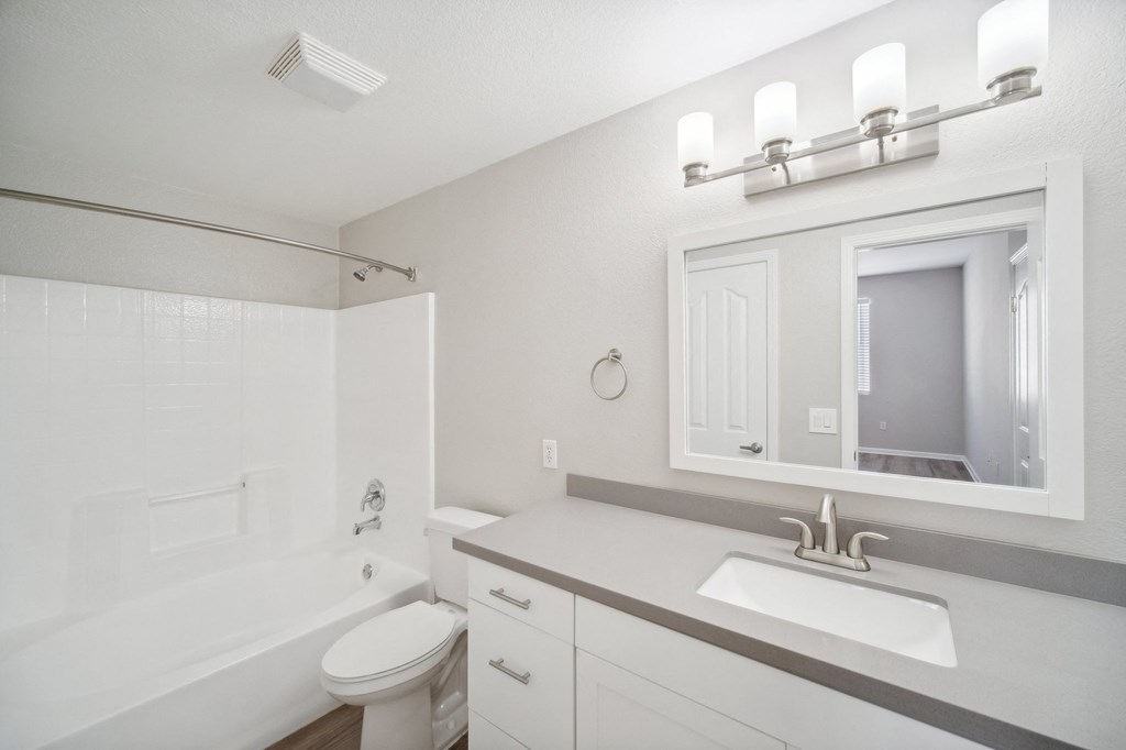 a bathroom with a sink and a tub and a mirror