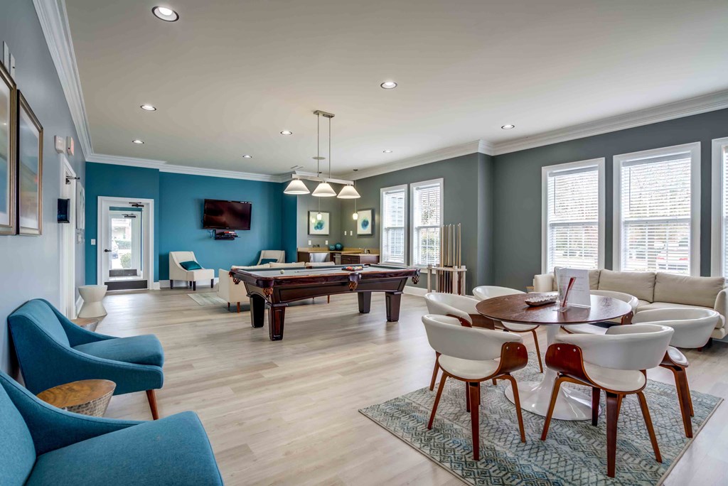 a living room with a pool table and a dining room