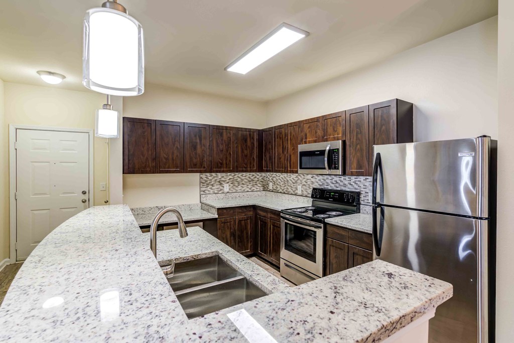 a kitchen with stainless steel appliances and granite counter tops