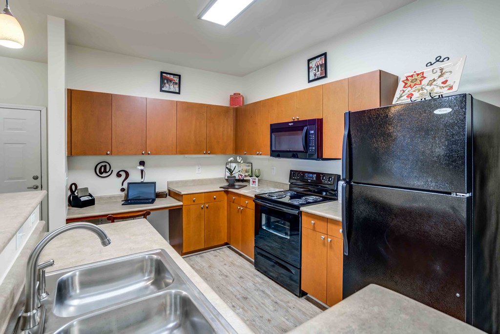 a kitchen with black appliances and wooden cabinets