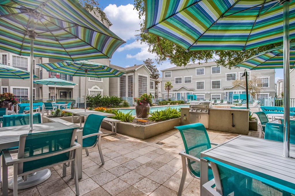 a patio with tables and chairs and umbrellas