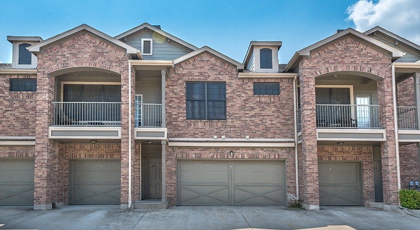 a large brick house with two garage doors