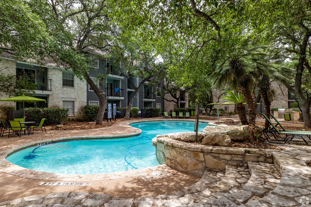 a swimming pool with trees and a building in the background