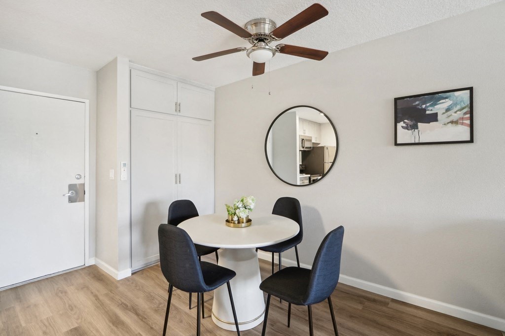 a dining room with a table and chairs and a ceiling fan