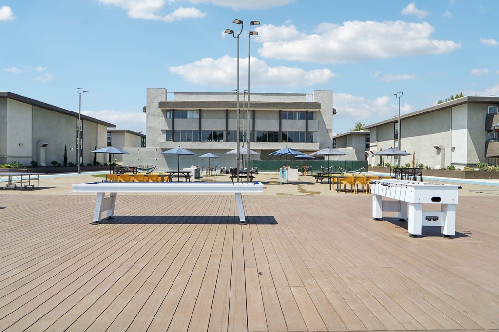a white bench on a wooden deck in front of a building