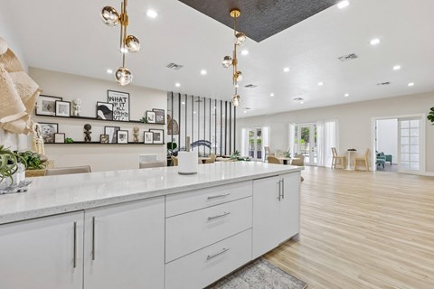 A modern kitchen with white cabinets and a marble countertop.
