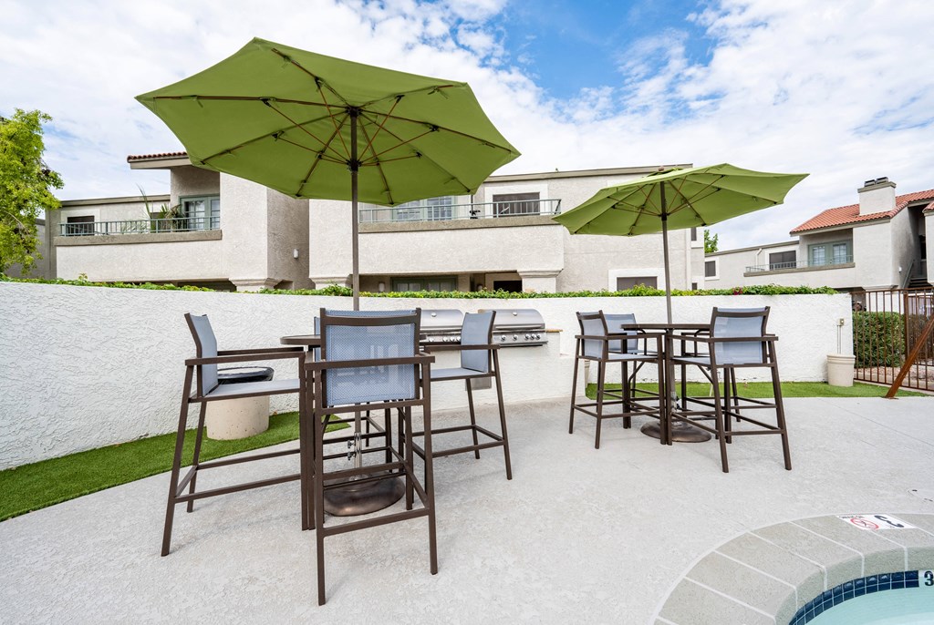 a patio with chairs and umbrellas and a pool