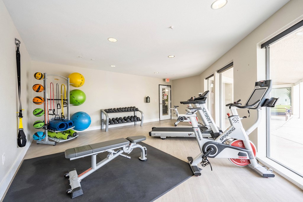 a home gym with exercise equipment and a window