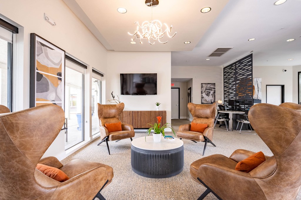 a living room with chairs and a table and a television