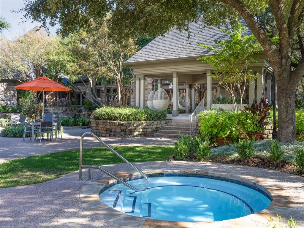 a hot tub in the backyard of a house with a porch