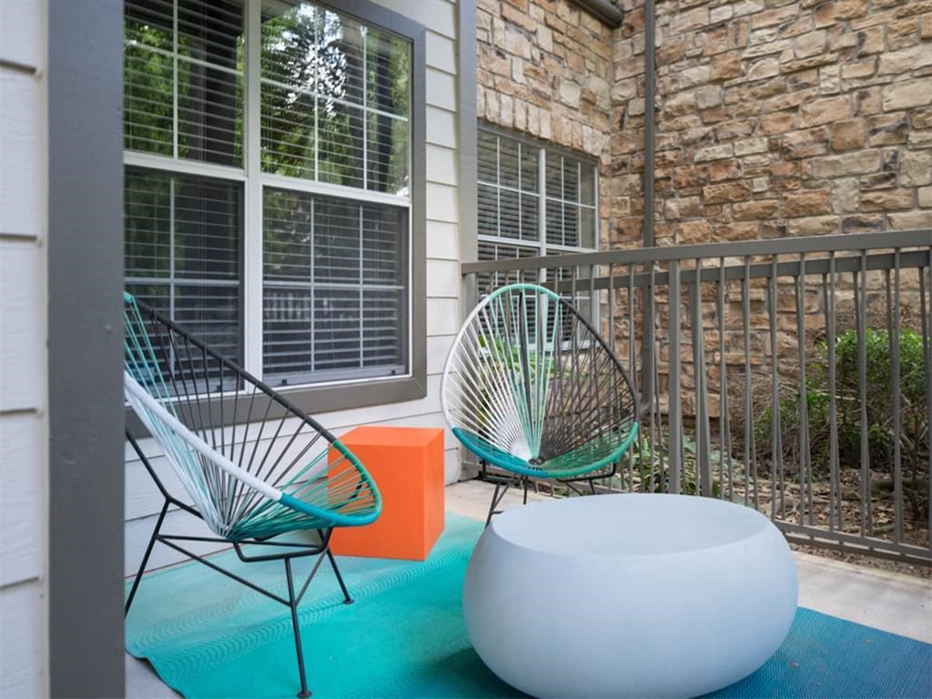 a patio with two chairs and a table on a porch